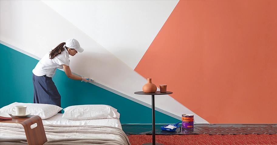 Uma mulher pintando uma parede