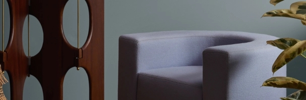 Ambiente em que destaca a cor do anos de 2024, a cor Conforto, com destaque para a cadeira  cinza  que combina com a cor ao fundo | Parede está na Cor Conforto