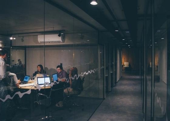 Pessoas reunidas em um escritório com pouca luminosidade
